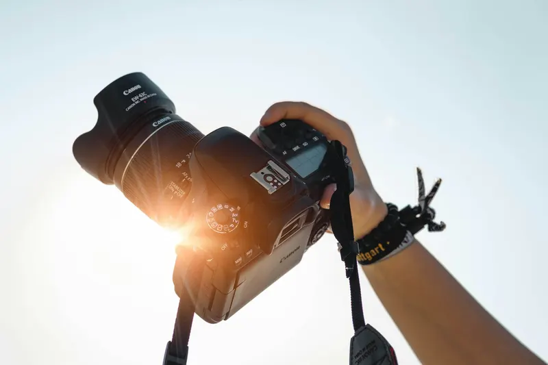 Hands holding a camera against the sun